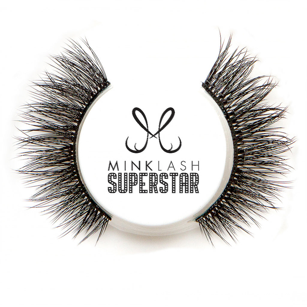 Prim-plan cu o pereche de gene "Showstopper" scoasă din cutie, arătând în detaliu construcția manuală, banda subțire și textura bogată, multidimensională, a fibrelor Faux Mink.